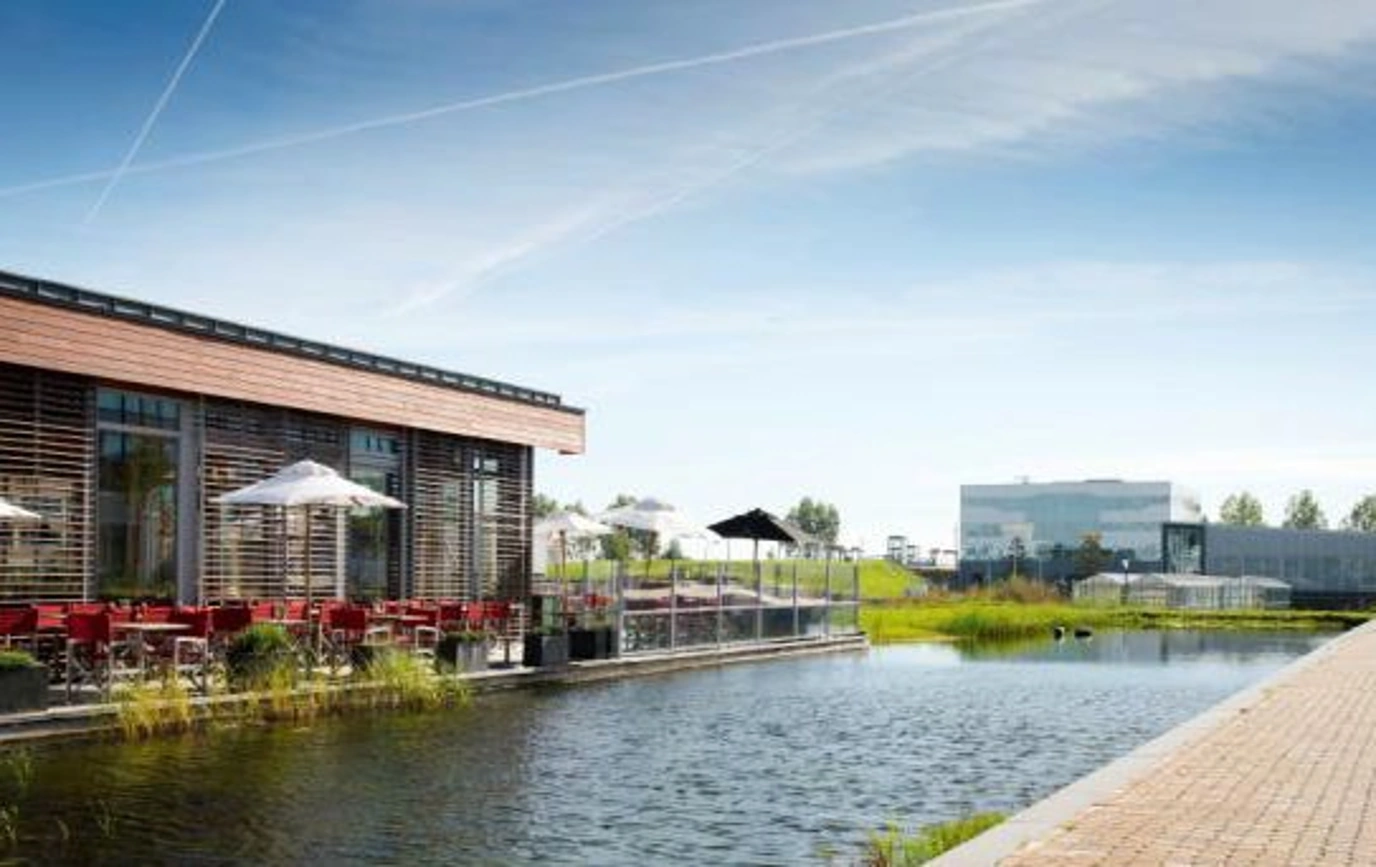 Modern kantoorgebouw Scorpius met terras aan het water op een zonnige dag.