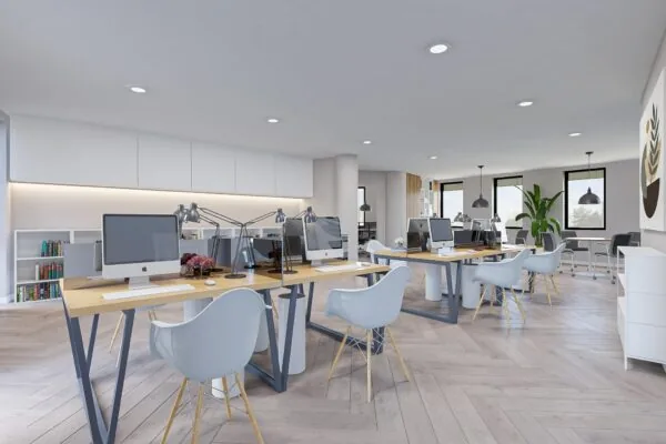 Modern ingericht kantoor aan de Koningsweg met open werkplekken, iMacs en veel natuurlijk licht.