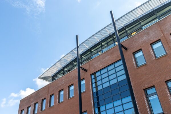 Buitenaanzicht van het moderne kantoorgebouw Veldzigt met rode bakstenen en grote glazen ramen.