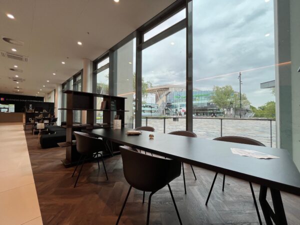 Moderne loungeruimte met werkplekken en uitzicht op het Herculesplein in Utrecht.