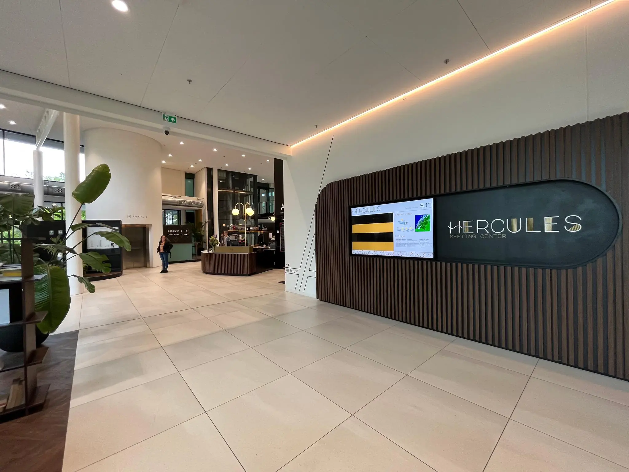 Ingang van het Hercules Meeting Center met informatiebord en moderne receptie.