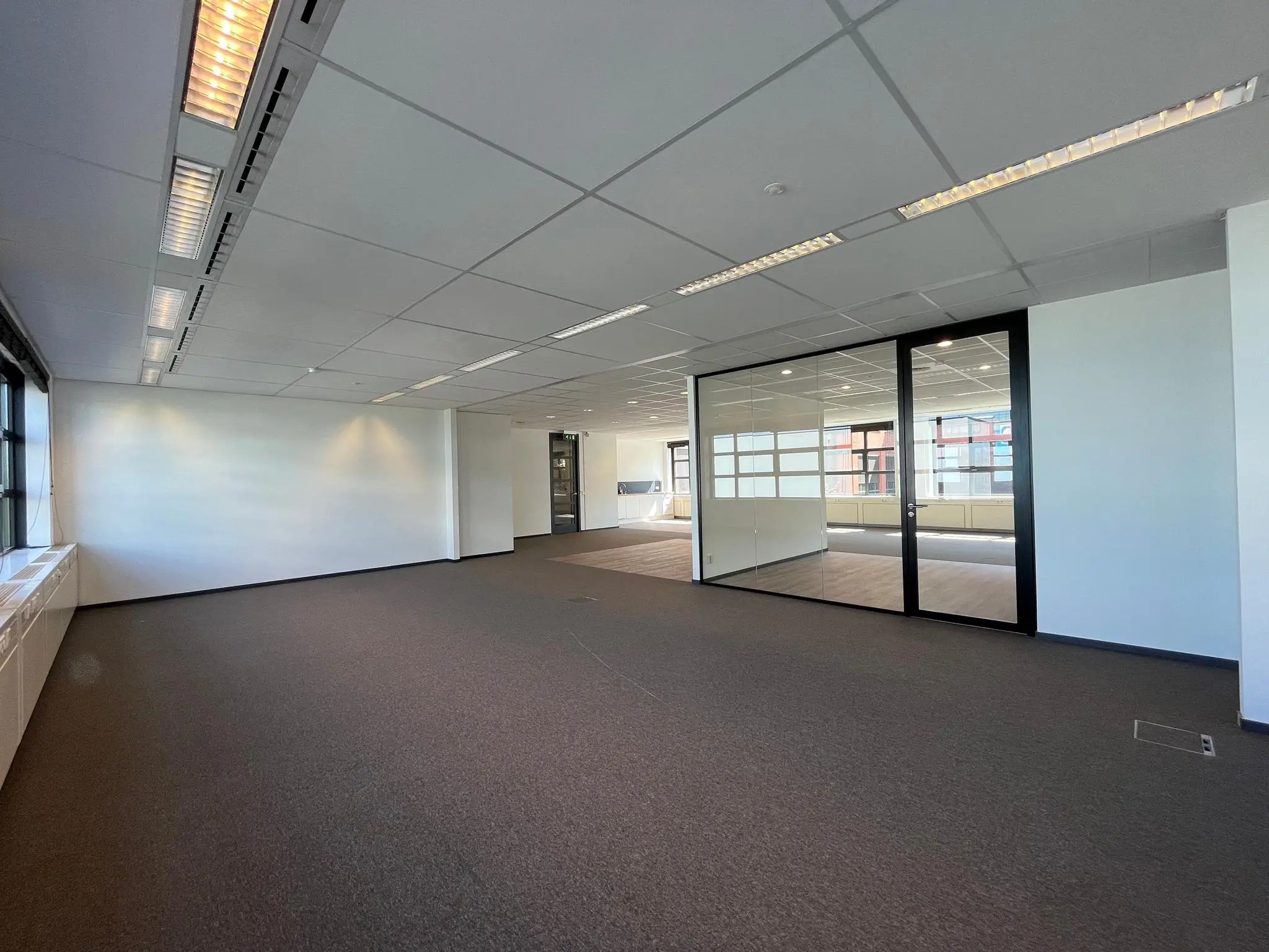 Licht en modern kantoorpand aan de Zonnebaan met glazen vergaderruimte en systeemplafond.