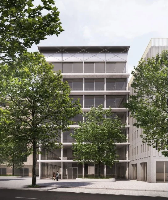 Modern kantoorgebouw aan de Grasweg in Amsterdam, omringd door bomen en met glazen gevel.