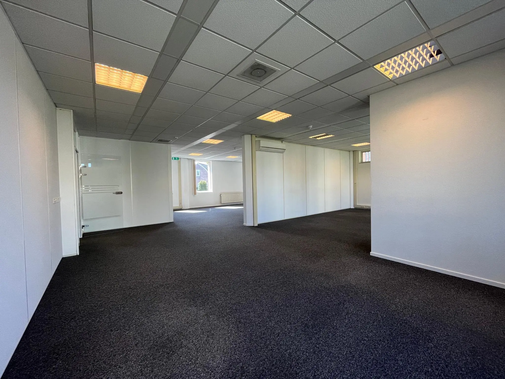 Leegstaand, modern kantoorinterieur aan de Utrechtseweg met systeemplafond en tapijtvloer.