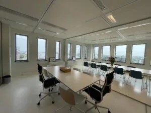 Vergaderruimte in het kantoorgebouw IJDok met glazen wand, moderne inrichting en uitzicht op de stad.