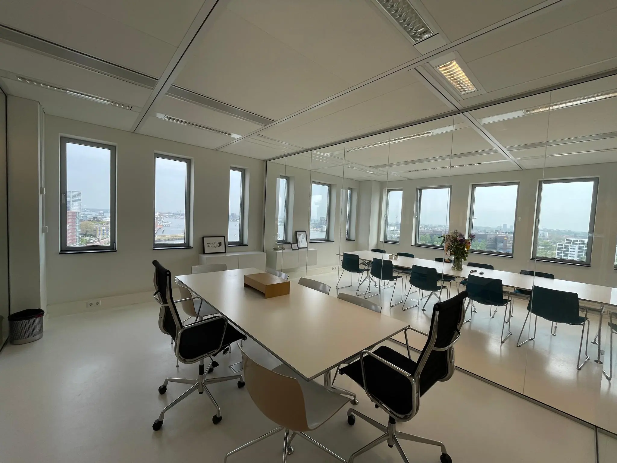 Vergaderruimte in het kantoorgebouw IJDok met glazen wand, moderne inrichting en uitzicht op de stad.