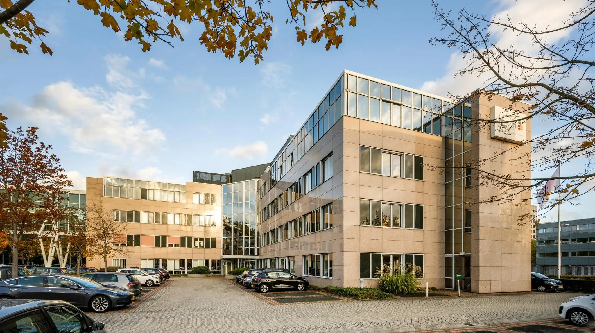 Kantoorgebouw van de organisatie Wisselwerking met parkeergelegenheid op de voorgrond.