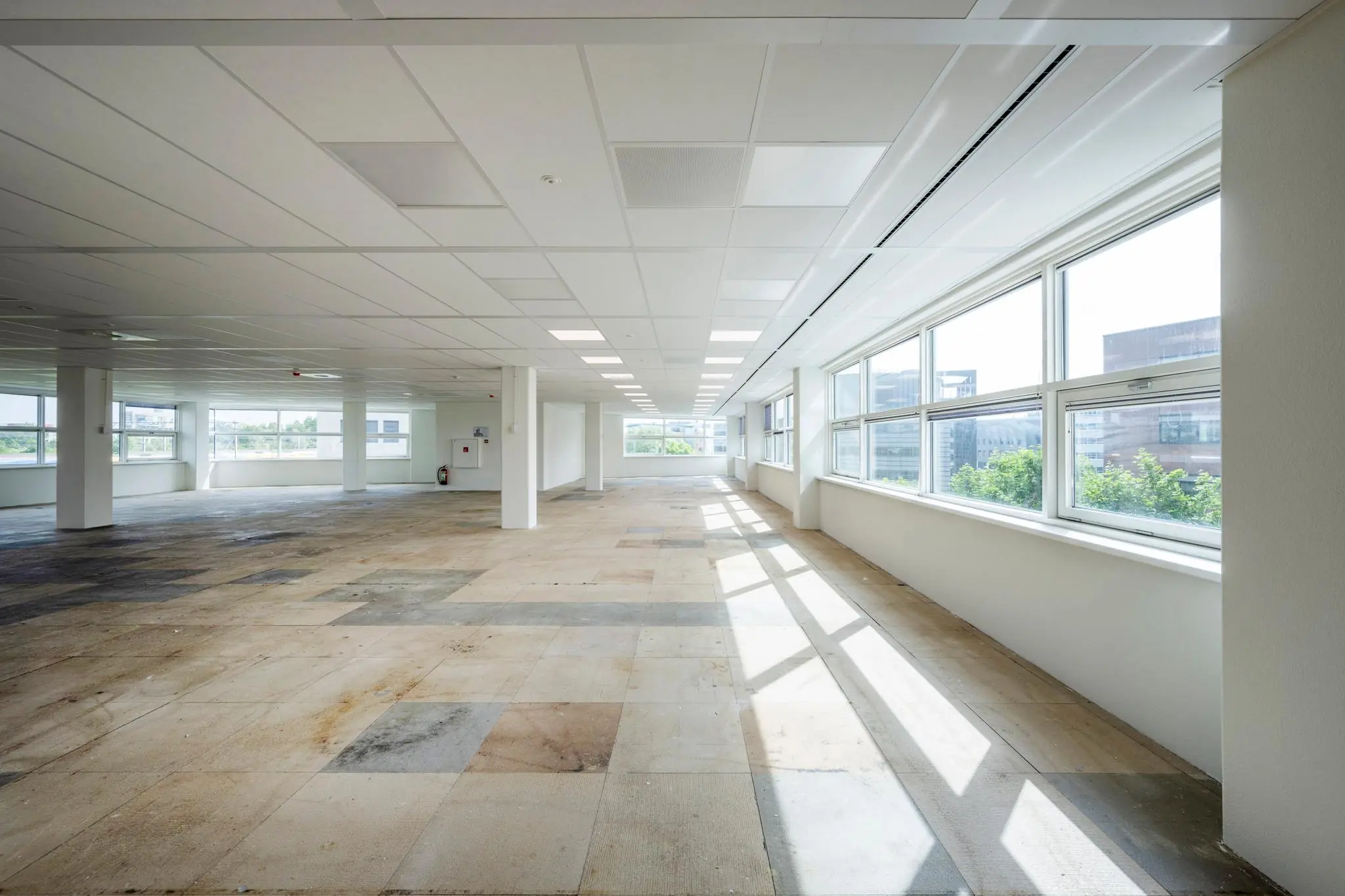 Lichte, lege kantoorruimte aan de Capellalaan met grote ramen en systeemplafond.