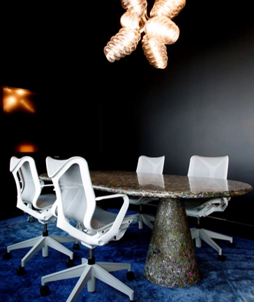 Moderne vergaderruimte aan de Moermanskkade met een ovale tafel, witte bureaustoelen en opvallende designverlichting.