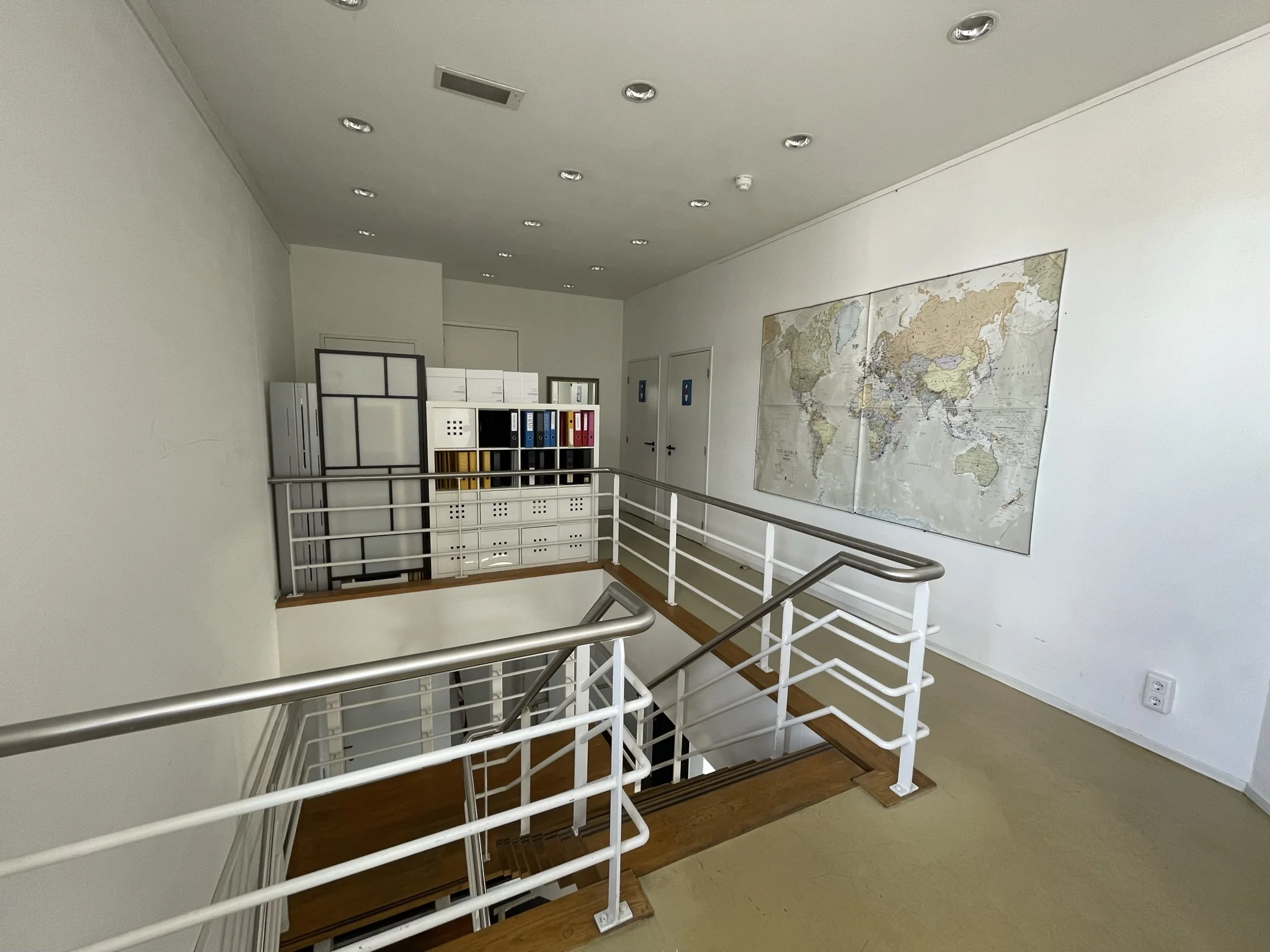 Trappenhuis in een kantoorruimte aan de Pilotenstraat met een wereldkaart aan de muur en een kast met ordners.