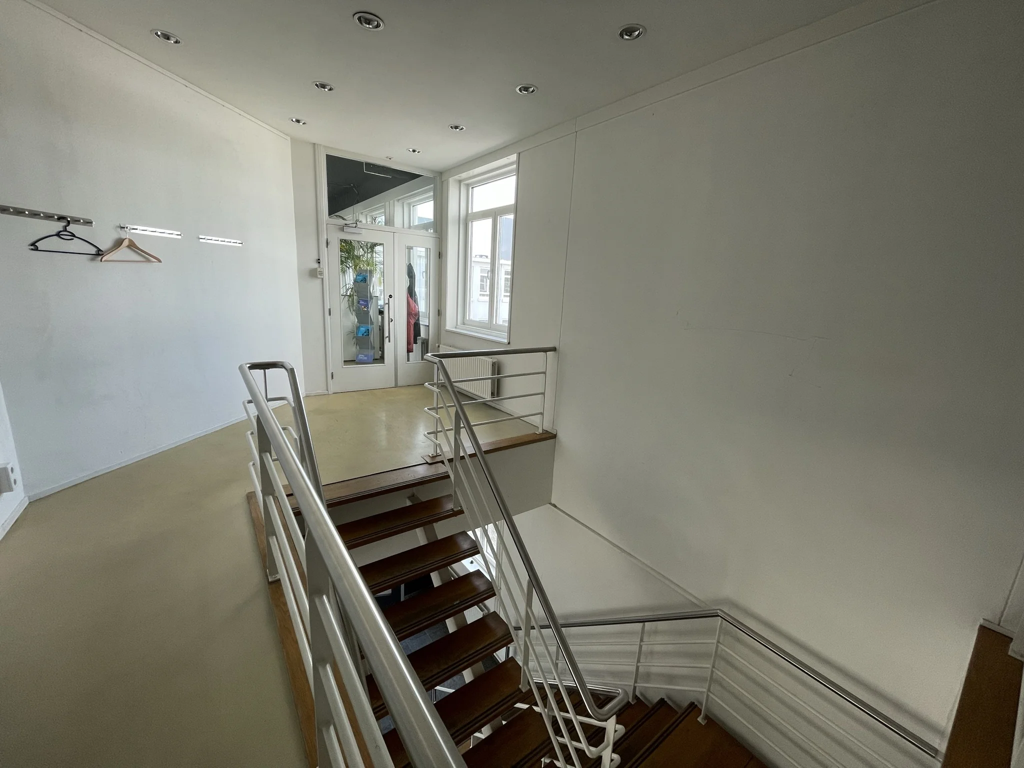 Trapopgang met houten treden en witte leuningen in een modern kantoorpand aan de Pilotenstraat.