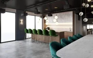 Moderne kantoorruimte aan de Grasweg met een open keuken, een marmeren tafel en groene fluwelen barkrukken.