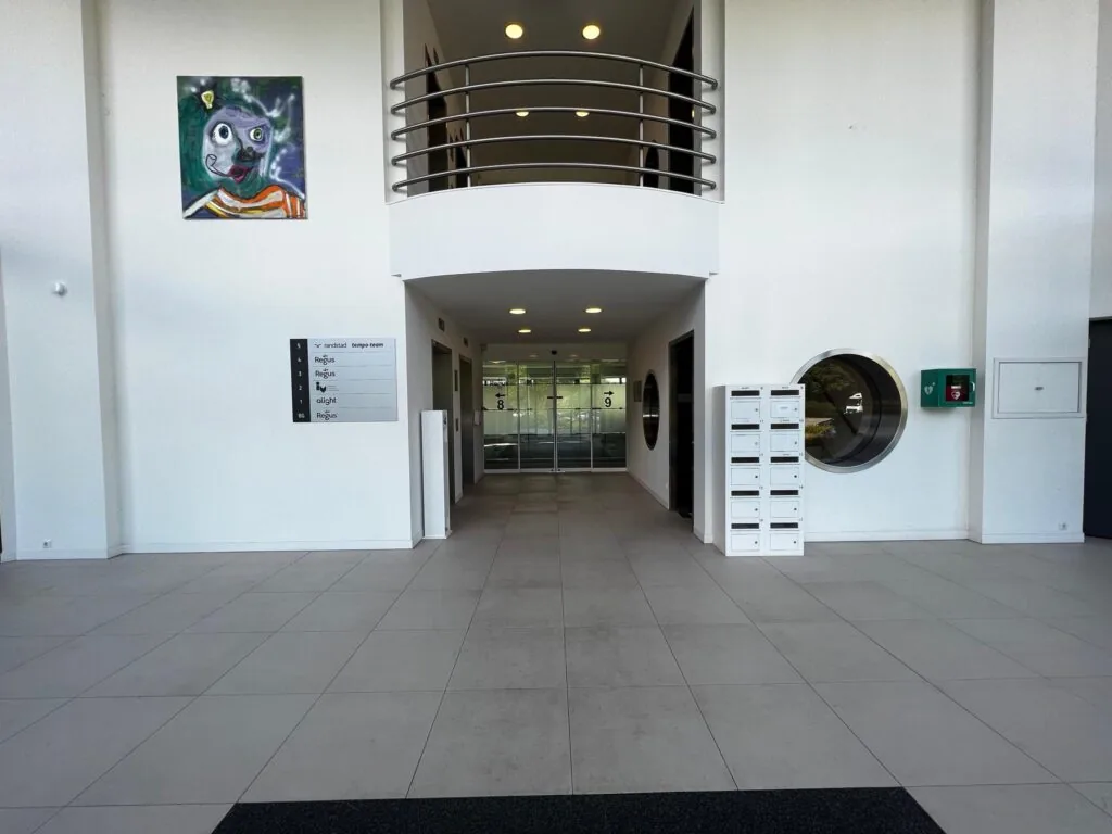 Ingang en lobby van kantoorgebouw Nevelgaarde met postvakken, kunstwerk en bedrijfsnaambord.