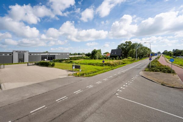 Kruispunt bij de Aalsmeerderweg met zicht op het Storage Center Aalsmeer en omliggende groene omgeving.