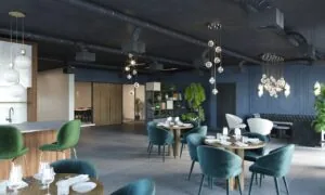 Moderne, sfeervol ingerichte restaurant- of lounge ruimte aan de Grasweg met fluwelen stoelen, hanglampen en plantenaccenten.