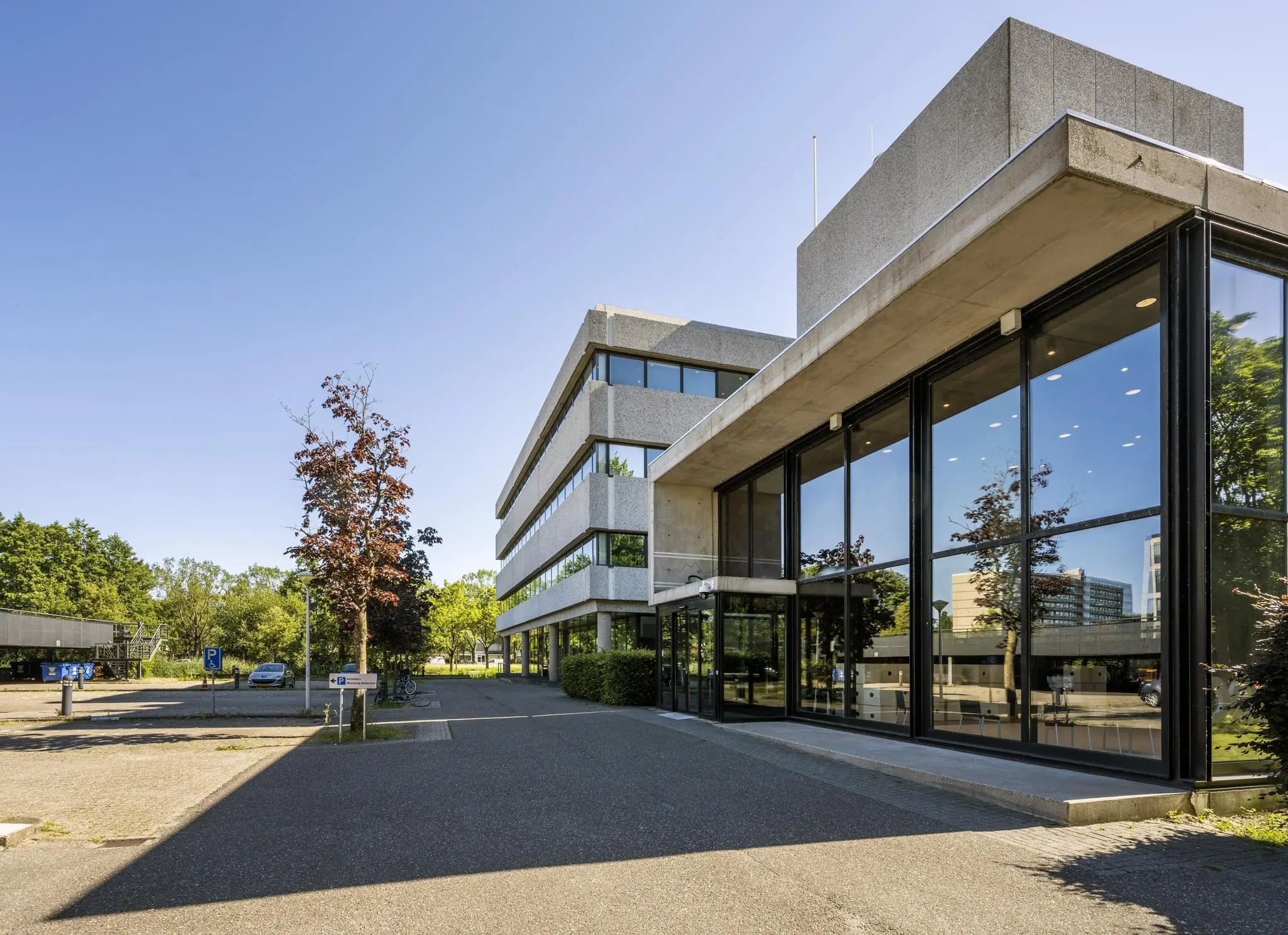 Modern kantoorgebouw aan de Prof. E.M. Meijerslaan met grote glazen gevel en omliggende parkeerruimte.