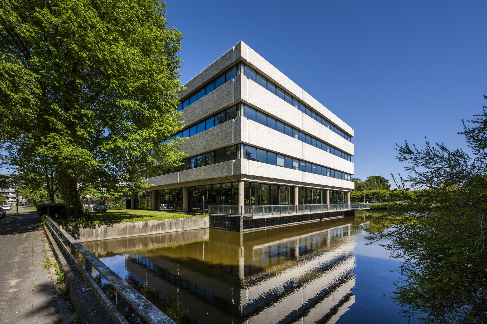 Kantoorgebouw aan de Prof. E.M. Meijerslaan weerspiegeld in een vijver op een zonnige dag.