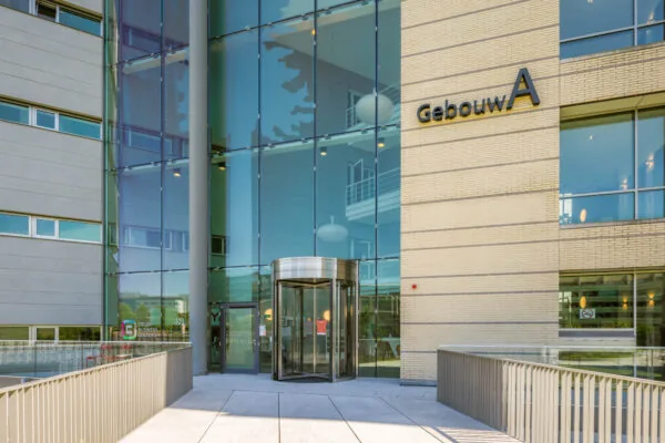 Ingang van Gebouw A aan de Papendorpseweg met glazen gevel en draaideur.