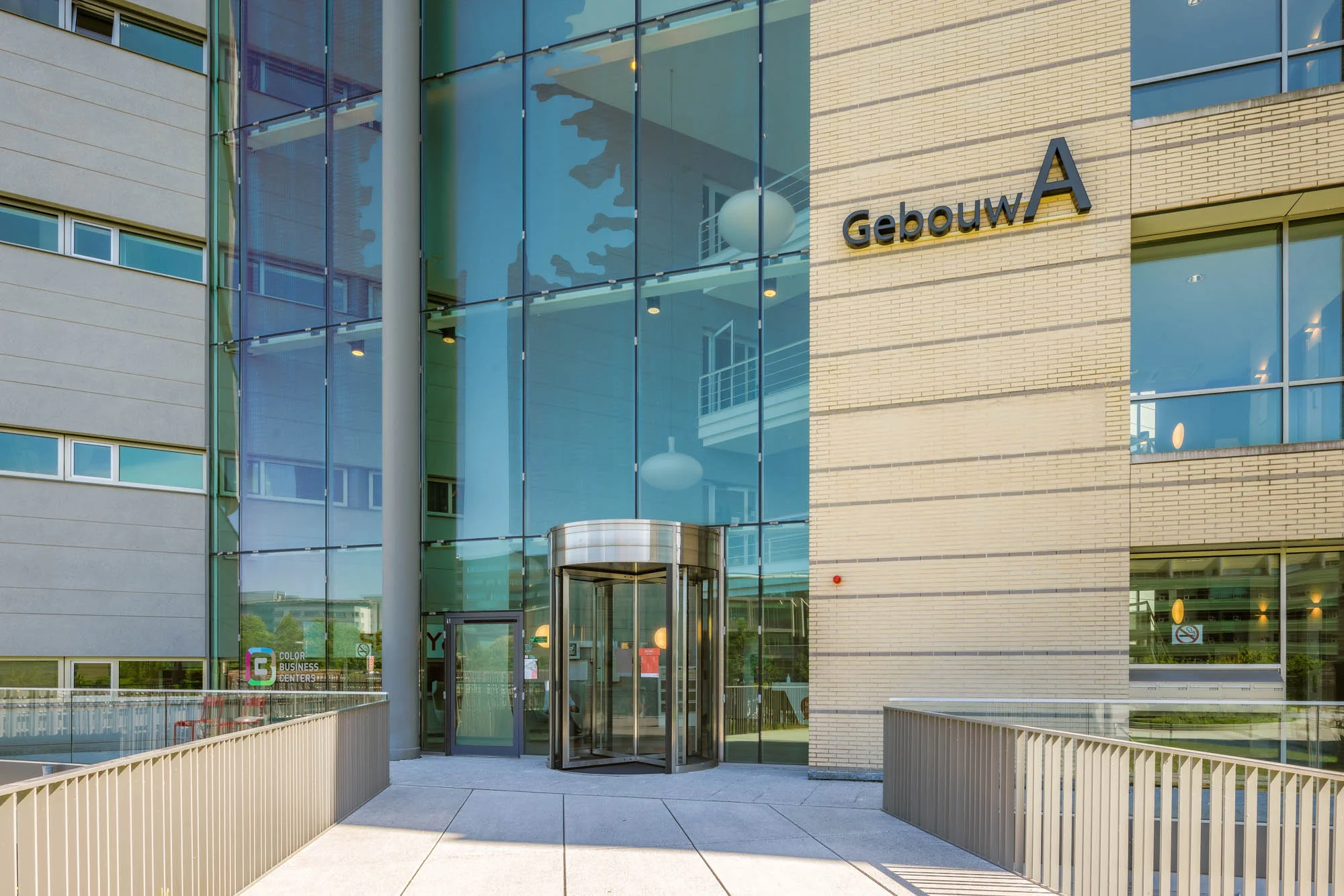 Ingang van Gebouw A aan de Papendorpseweg met glazen gevel en draaideur.