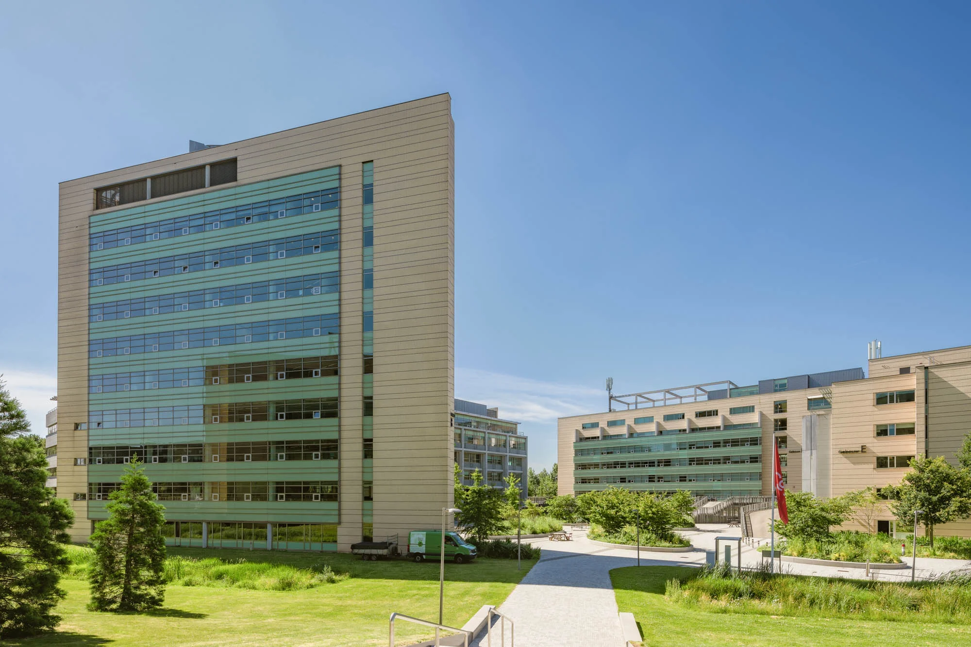 Modern kantoorgebouw aan de Papendorpseweg met veel glas en omliggend groen op een zonnige dag.