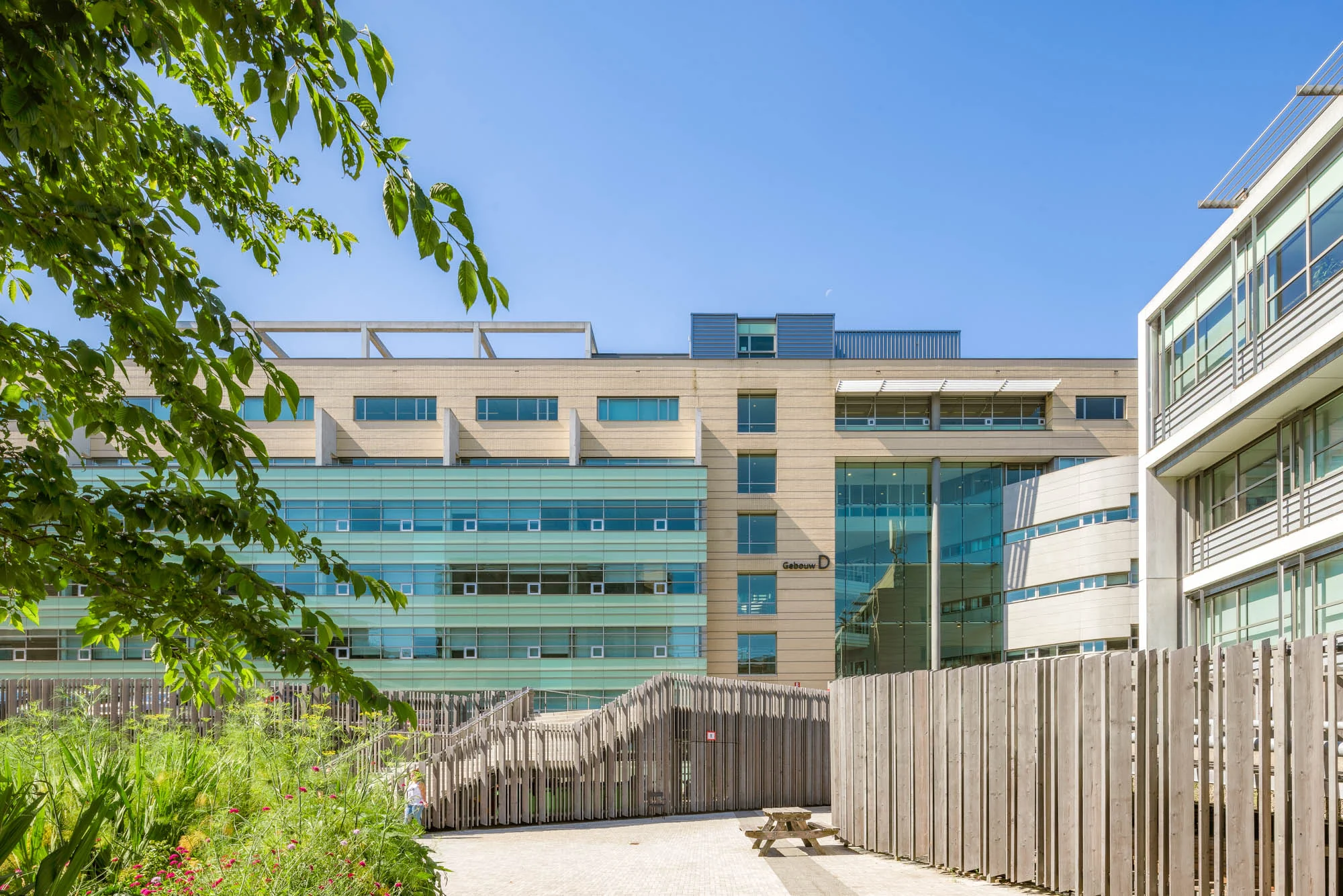 Modern kantoorgebouw Gebouw D aan de Papendorpseweg, omringd door groen en houten schuttingen.
