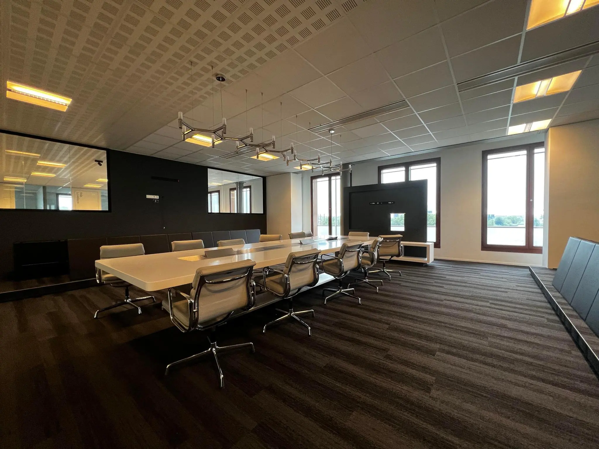 Moderne vergaderruimte aan de Hondiuslaan met een lange tafel, designstoelen en grote ramen met uitzicht.