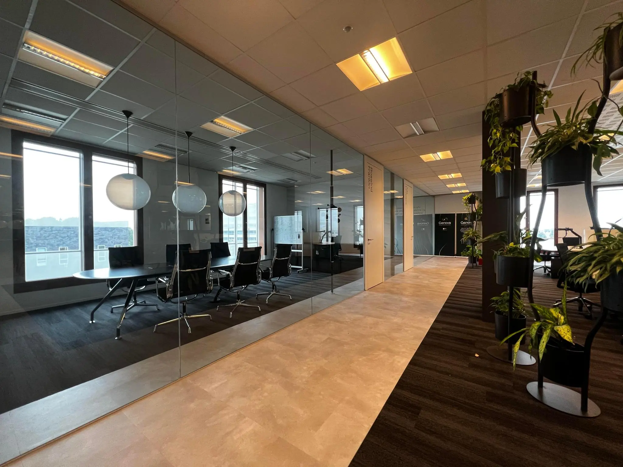 Moderne kantoorruimte aan de Hondiuslaan met vergaderruimte, glazen wanden en groene planten.