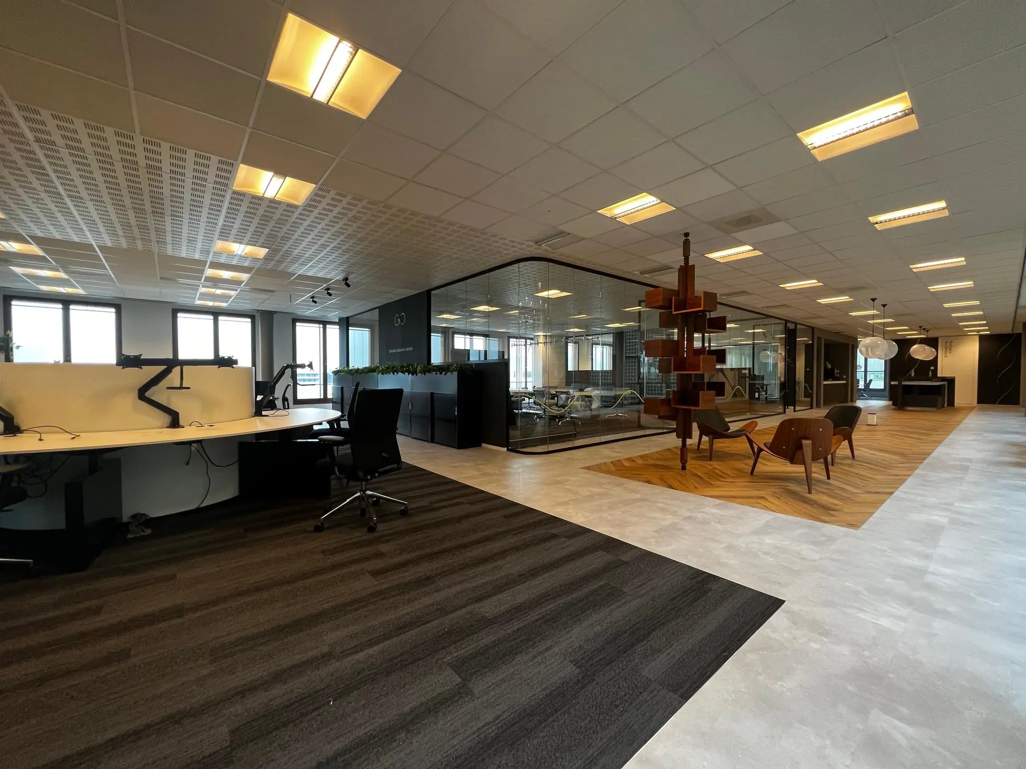 Moderne kantoorruimte aan de Hondiuslaan met flexwerkplekken, glazen vergaderruimte en zithoek met designstoelen.
