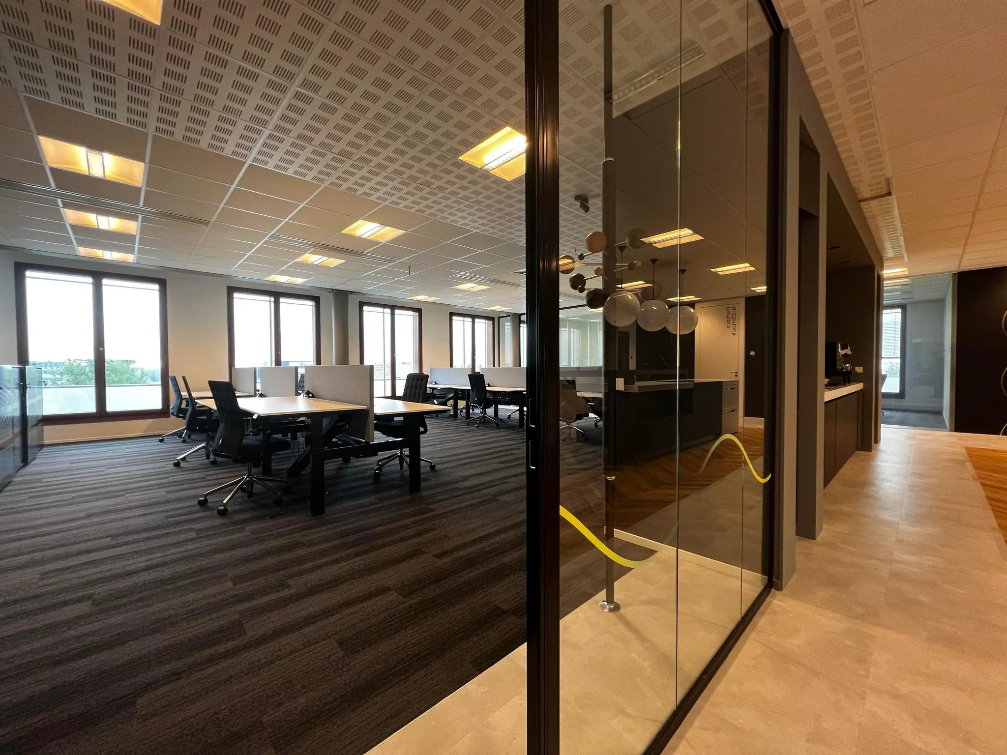 Moderne, ruime kantoorruimte aan de Hondiuslaan met bureaus, bureaustoelen en grote ramen die veel daglicht binnenlaten.