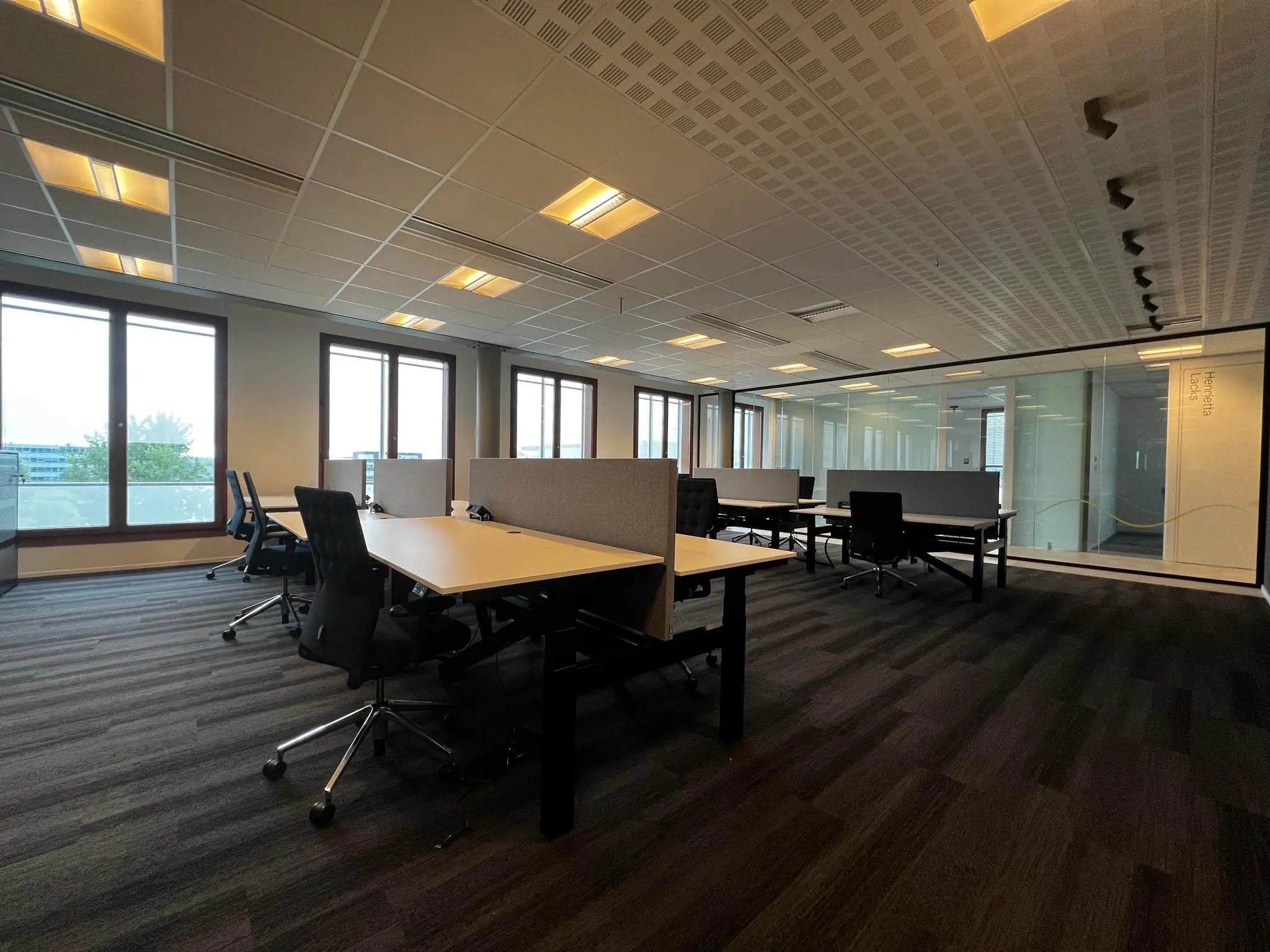 Modern kantoorinterieur aan de Hondiuslaan met werkplekken, bureaustoelen en grote ramen voor natuurlijk licht.