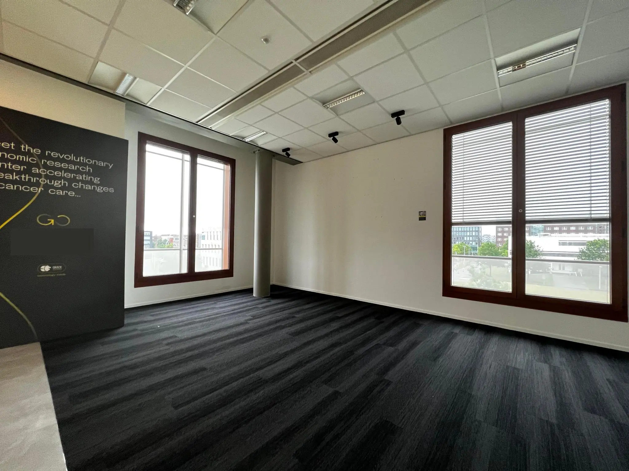 Moderne, lege kantoorruimte aan de Hondiuslaan met grote ramen en uitzicht op omliggende gebouwen.