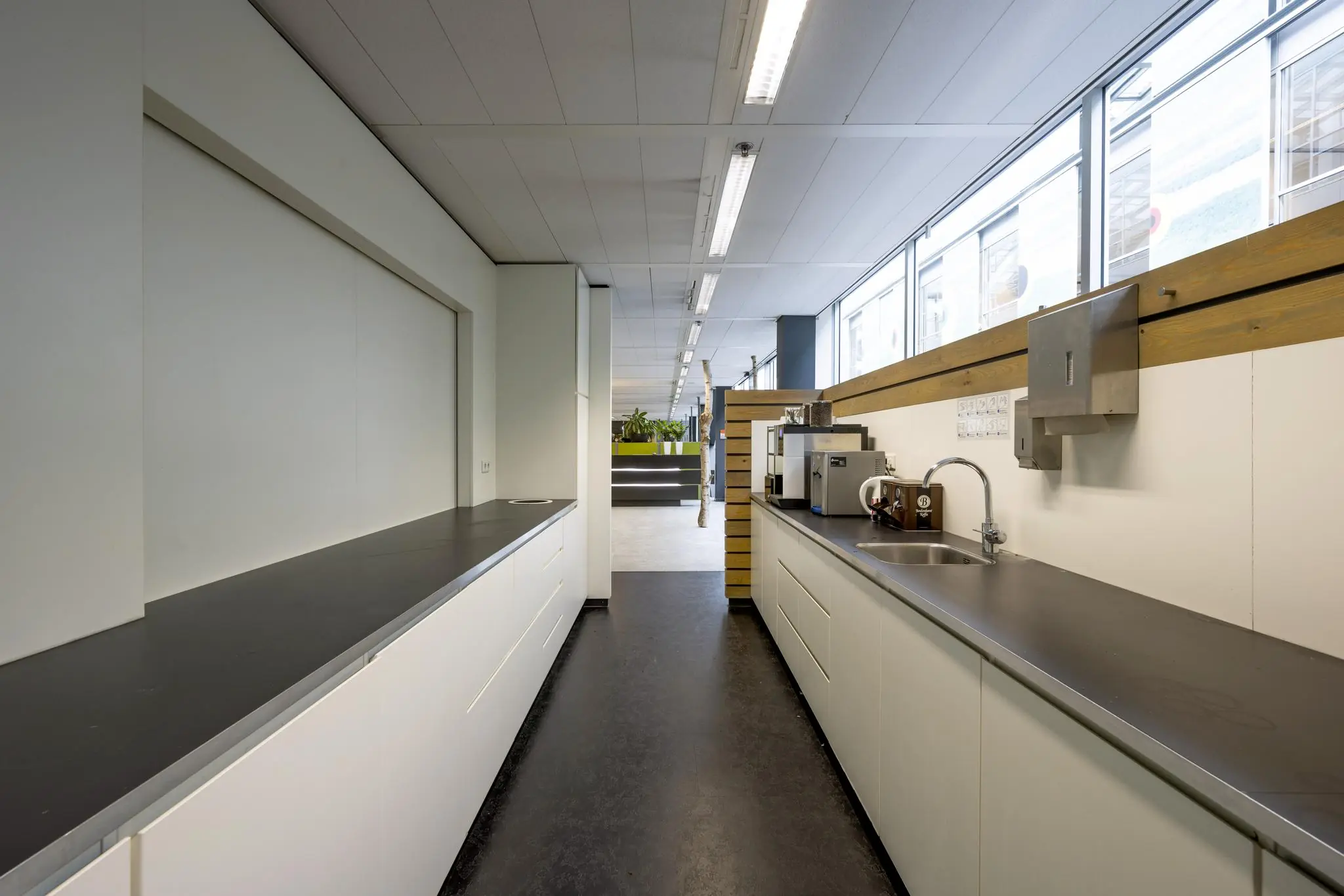 Moderne pantry met koffiezetapparaat en spoelbak in een kantoor aan de Jacob Bontiusplaats.