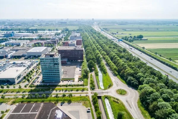 Luchtfoto van bedrijvenpark Rijnzathe met naastgelegen snelweg en groenvoorzieningen.