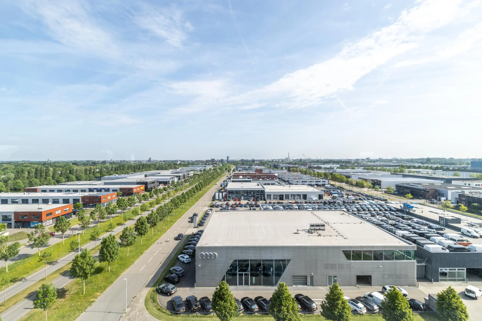 Luchtfoto van bedrijventerrein Rijnzathe met moderne bedrijfspanden, parkeerplaatsen en brede groenstroken.