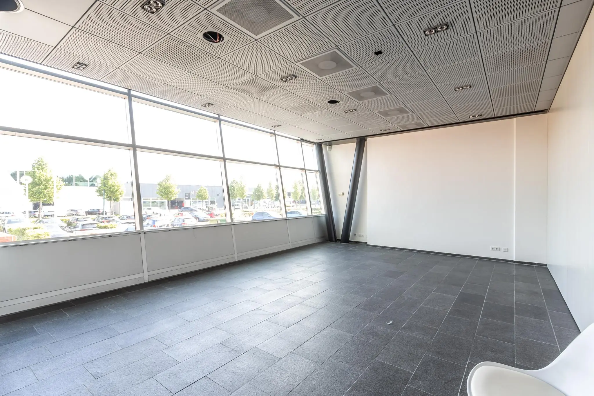 Lichte, lege kantoorruimte met grote ramen aan de straatzijde van het gebouw aan de Rijnzathe.