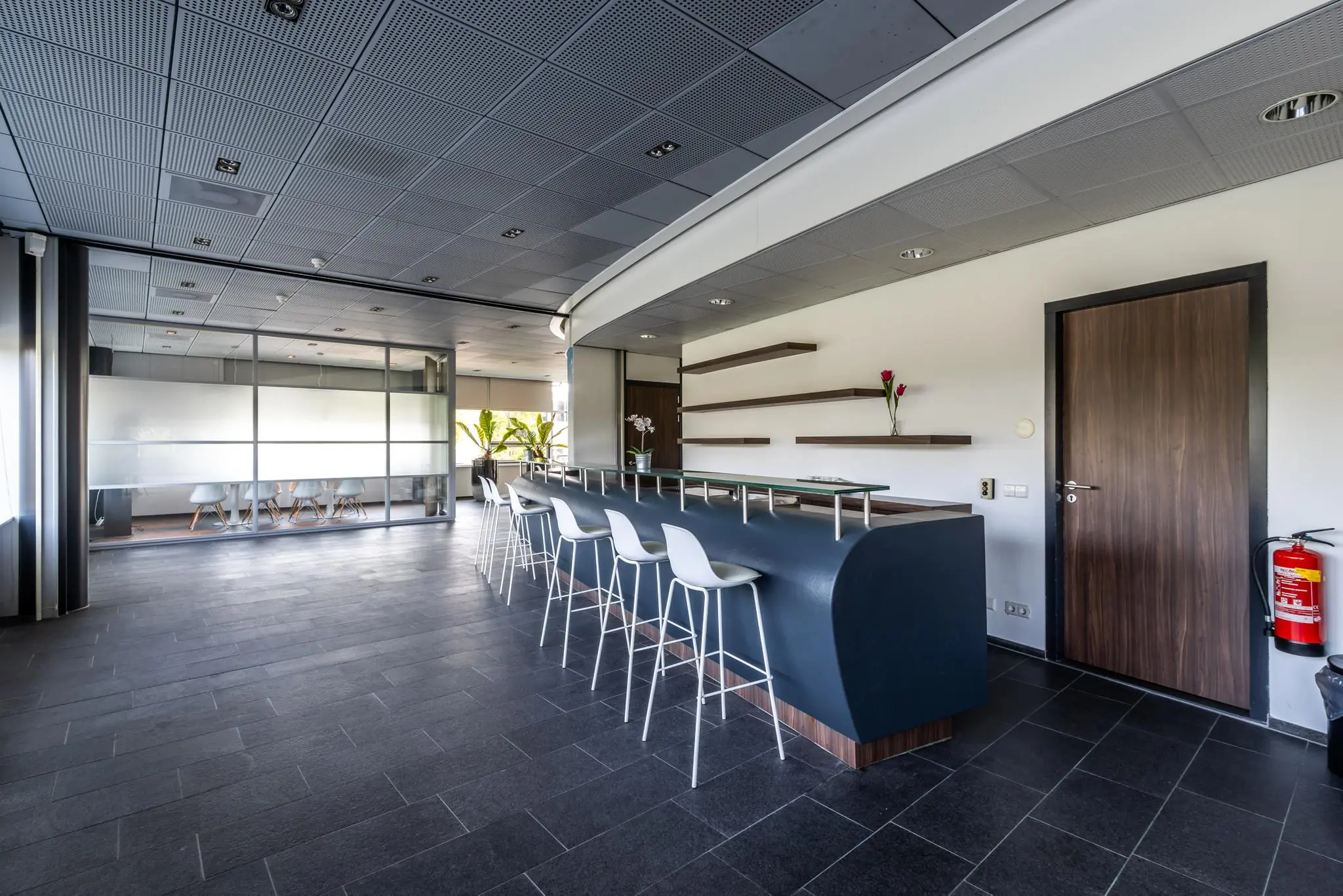Moderne kantoorruimte met een strakke bar en hoge stoelen bij Rijnzathe.