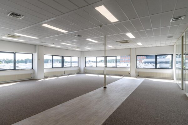 Lichte, lege kantoorruimte aan de Zonnebaan met grote ramen en systeemplafond.