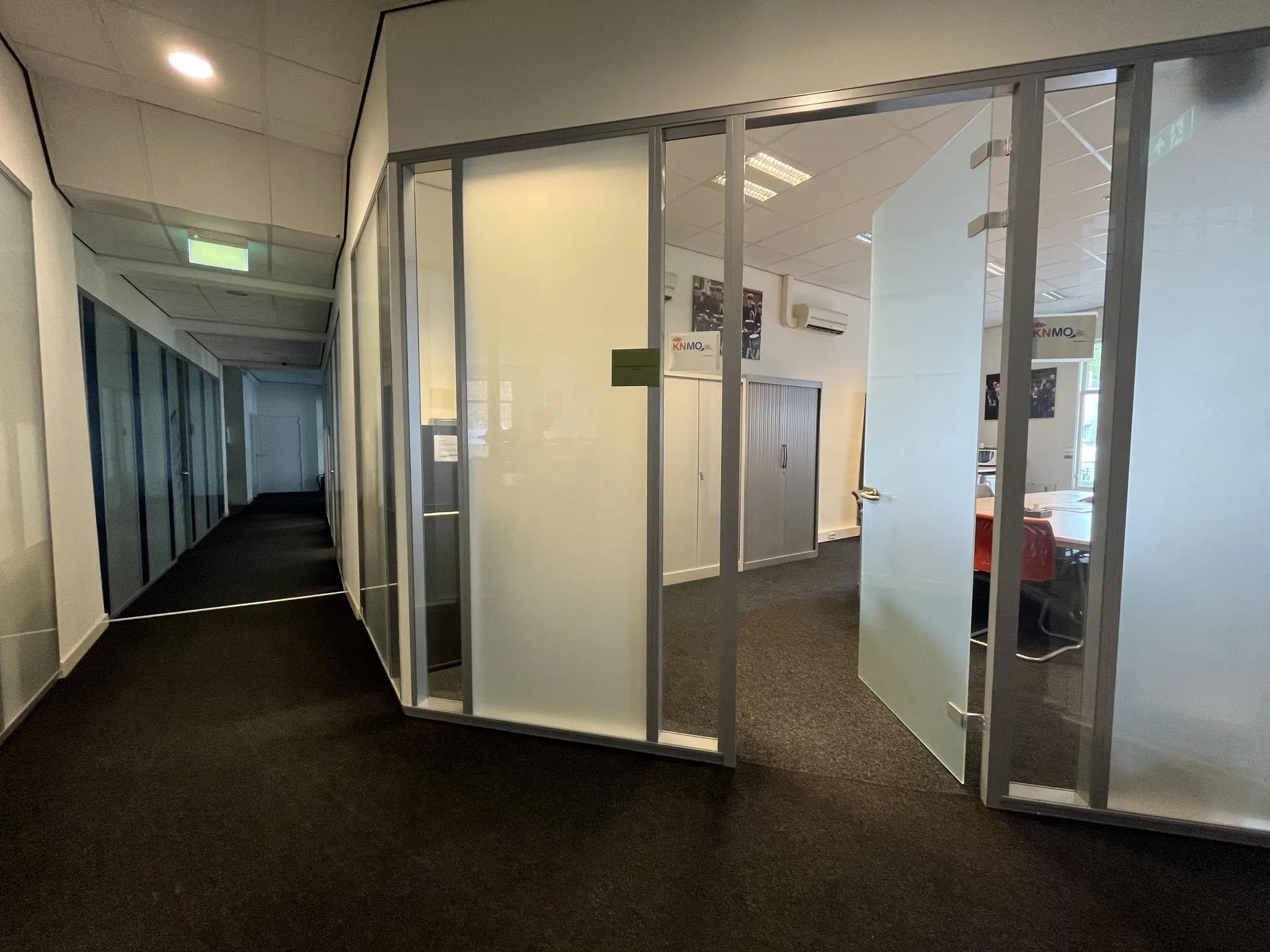 Gang met openstaande deur naar een vergaderruimte in een kantoor aan de Ganzenmarkt.