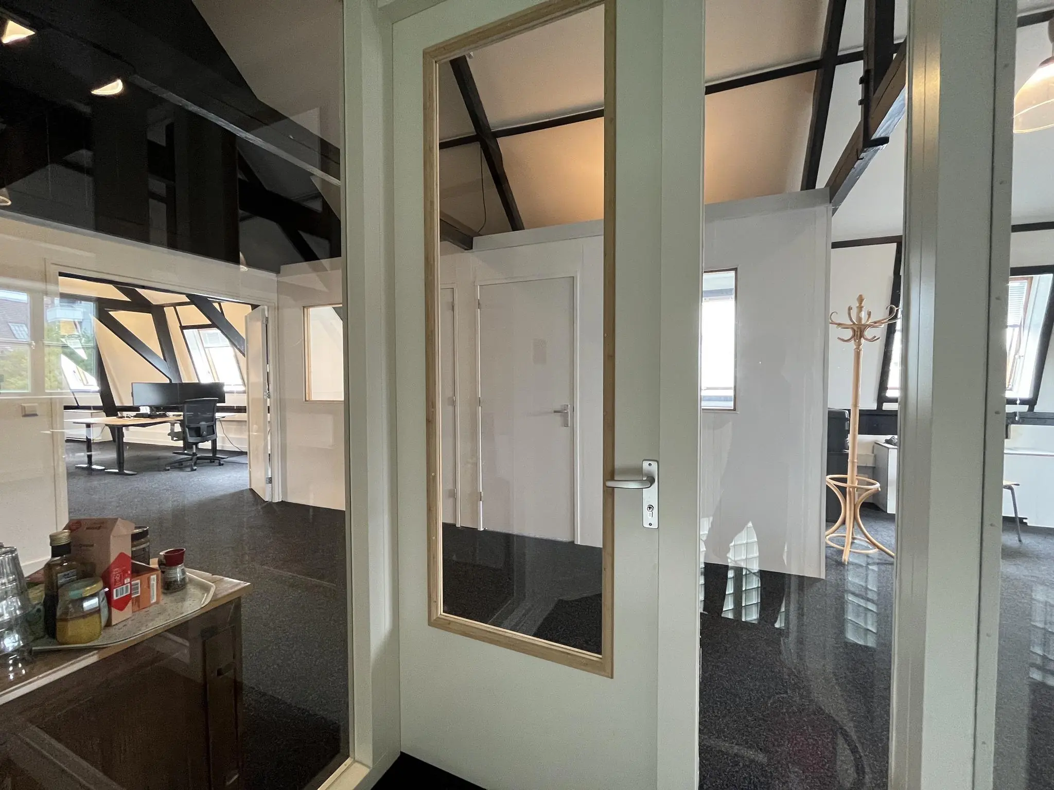 Moderne kantoorruimte aan de Ganzenmarkt met glazen deuren, bureaus en natuurlijk licht.