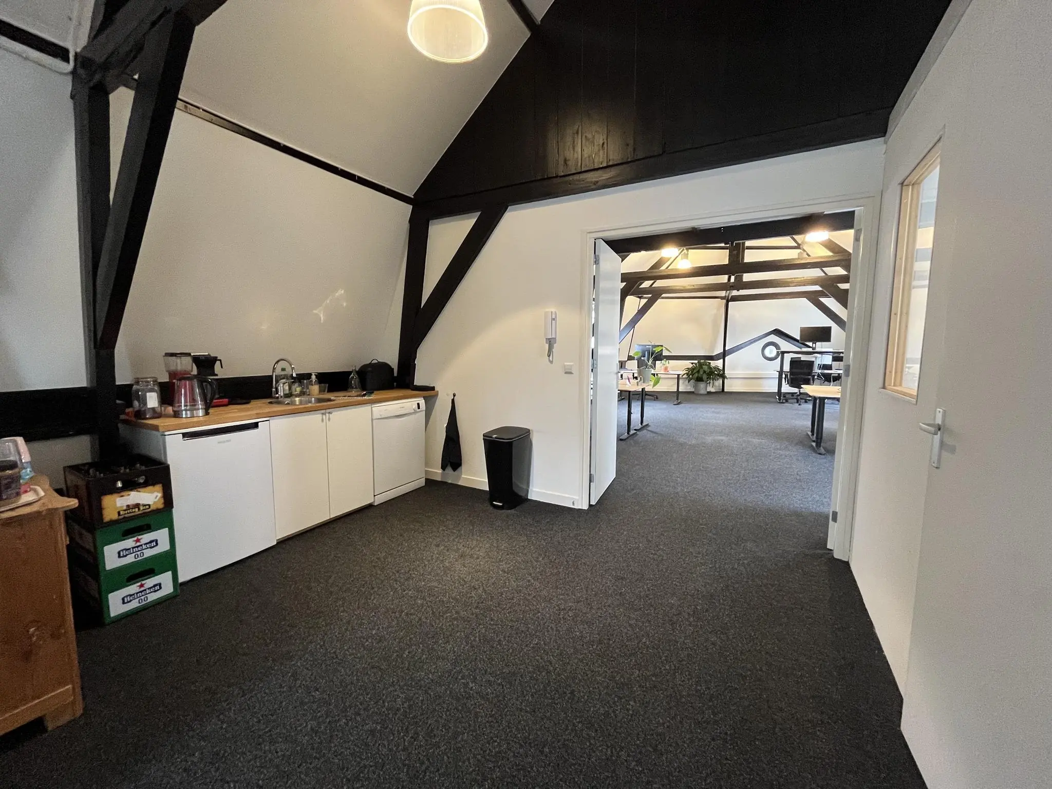 Kantoorruimte op de Ganzenmarkt met een open keukenhoek en zicht op een werkruimte met bureaus.