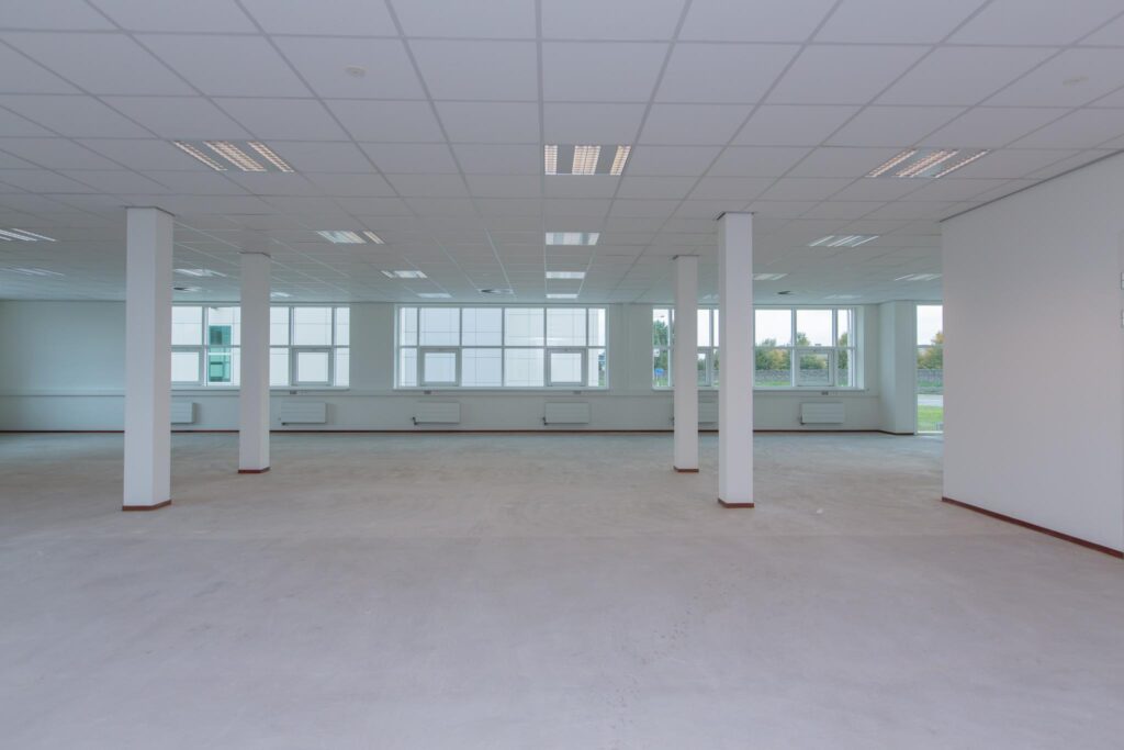 Leegstaand, ruim en licht kantoorinterieur aan het Rhijnspoor met grote ramen en systeemplafond.