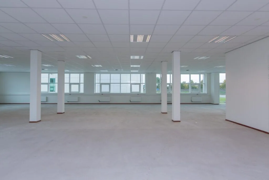 Leegstaand, ruim en licht kantoorinterieur aan het Rhijnspoor met grote ramen en systeemplafond.