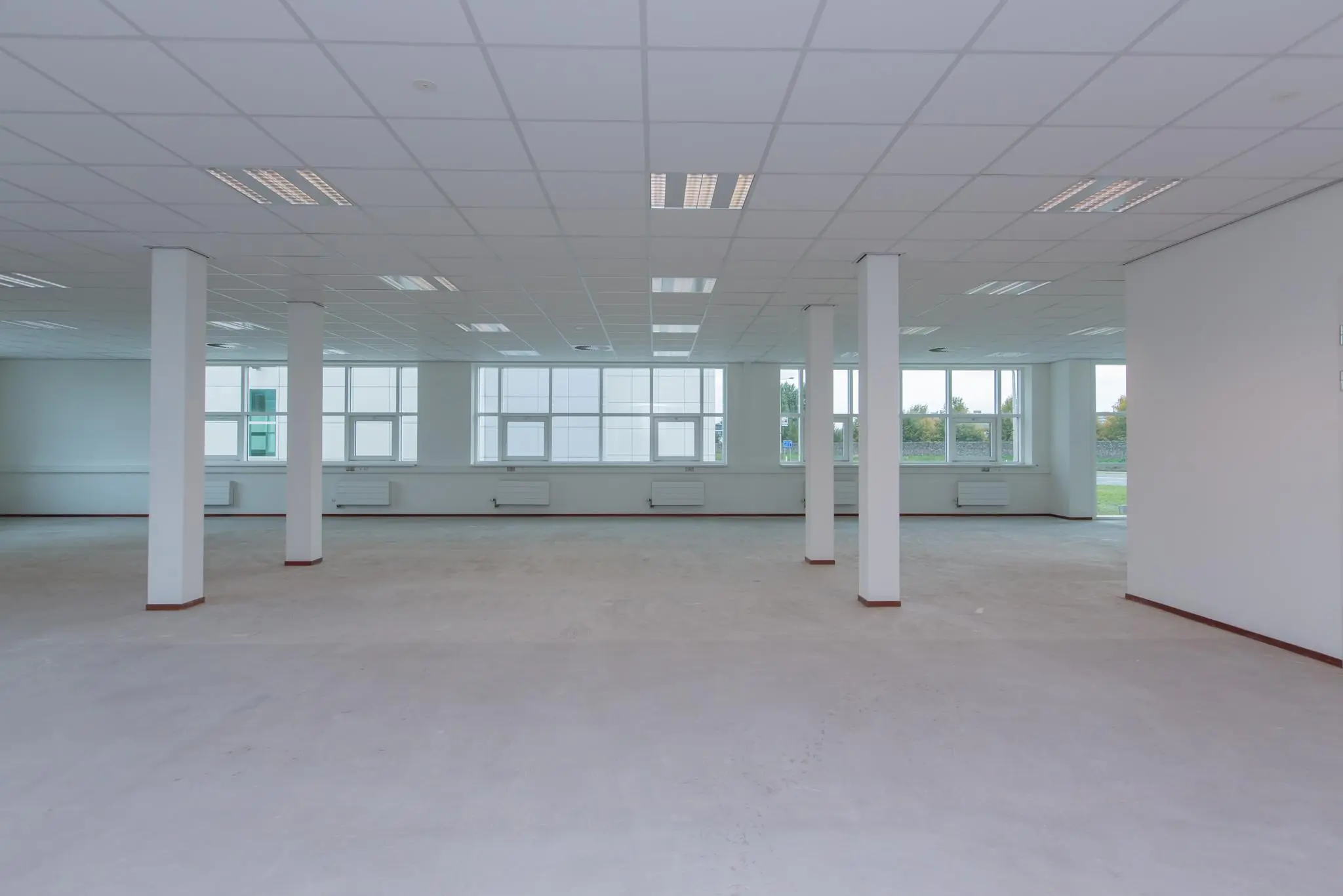 Leegstaand, ruim en licht kantoorinterieur aan het Rhijnspoor met grote ramen en systeemplafond.