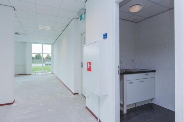 Lichte kantoorruimte aan het Rhijnspoor met kitchenette en uitzicht op groenstrook.