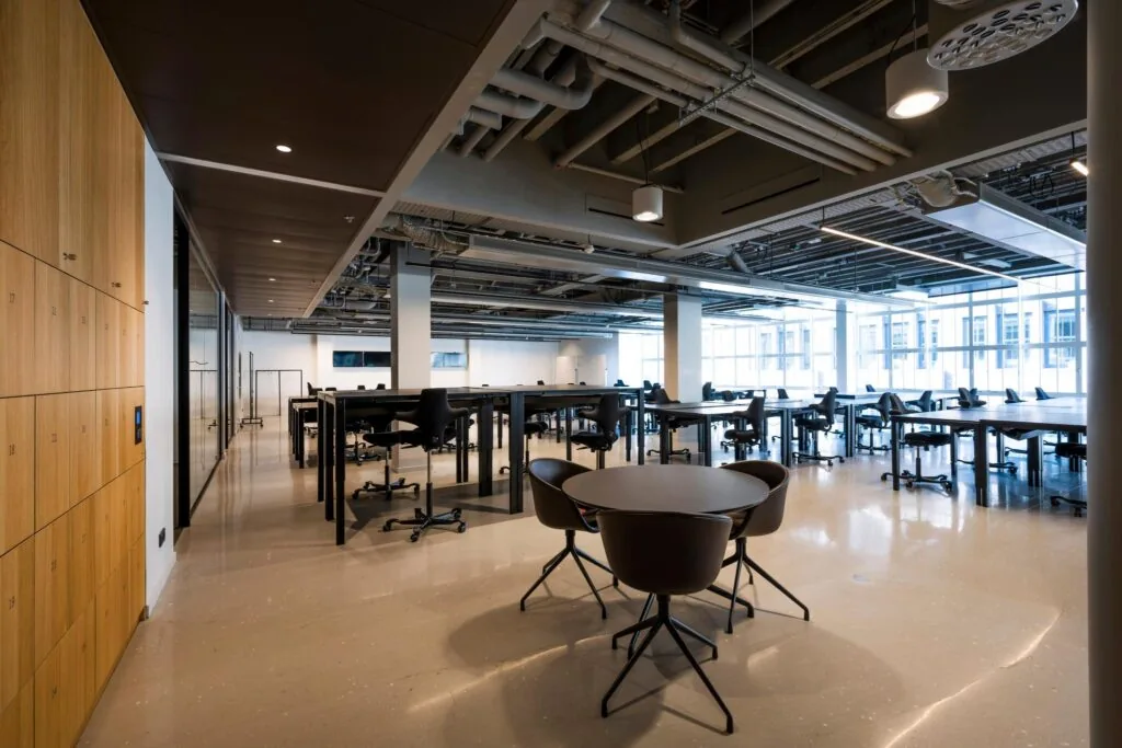 Moderne en ruime kantoorruimte aan het Rokin met bureaus, stoelen, lockers en grote ramen die natuurlijk licht binnenlaten.