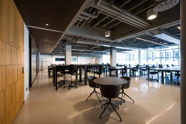 Moderne en ruime kantoorruimte aan het Rokin met bureaus, stoelen, lockers en grote ramen die natuurlijk licht binnenlaten.