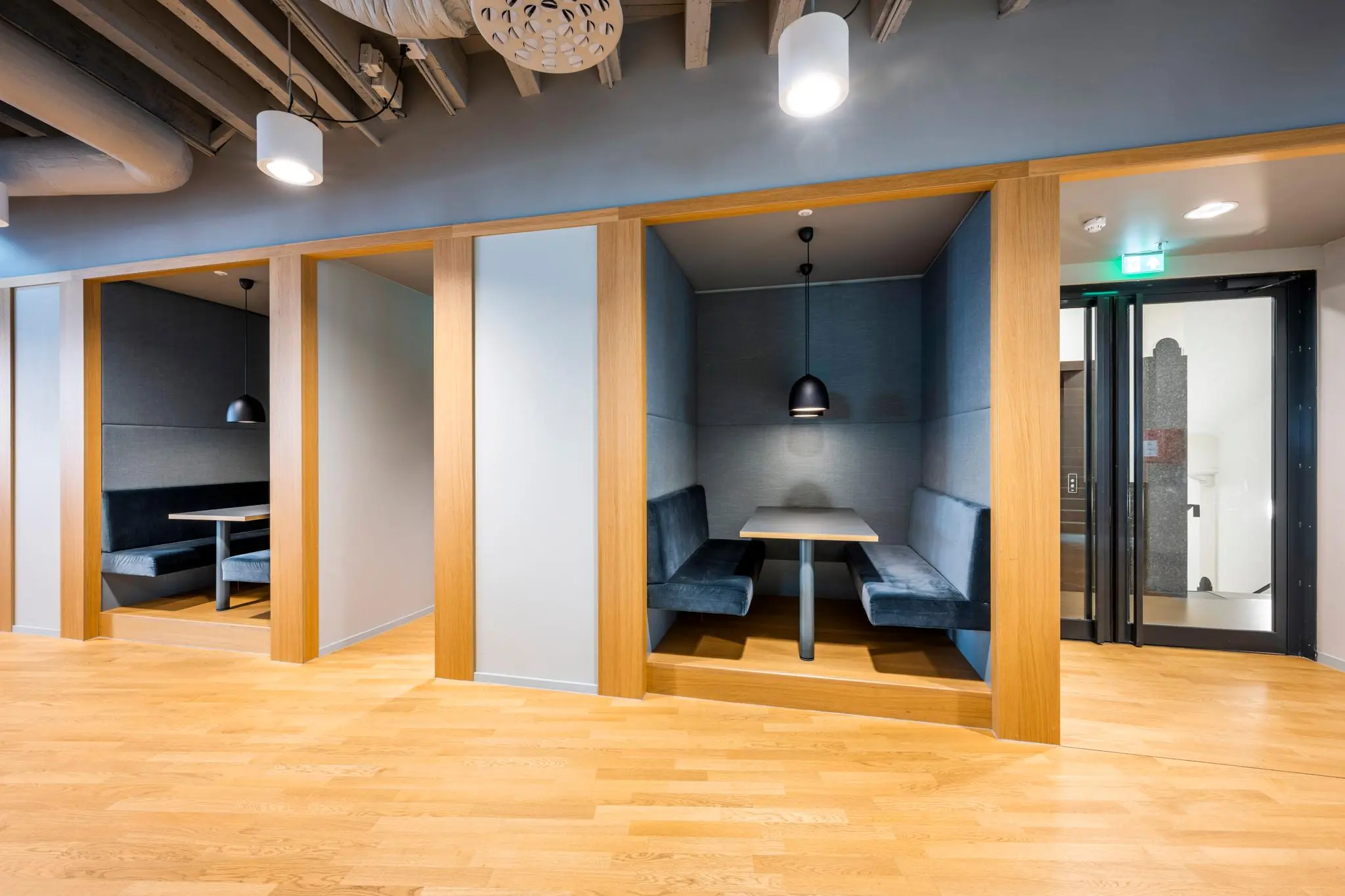 Moderne zitnissen met houten omlijsting en blauwe bekleding in een strak ingericht kantoor aan het Rokin.