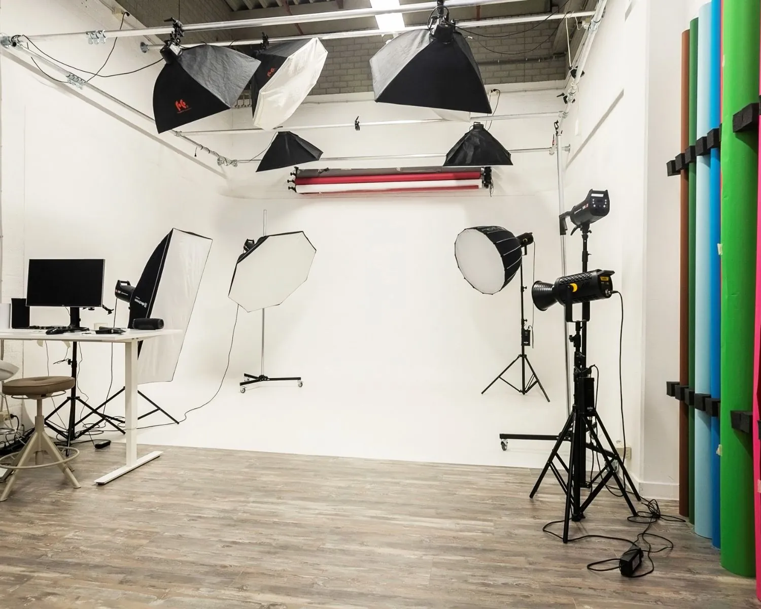 Professionele fotostudio met verlichting, achtergrondrollen en werkplek in een kantoorruimte aan de Bolderweg 2 in Almere.