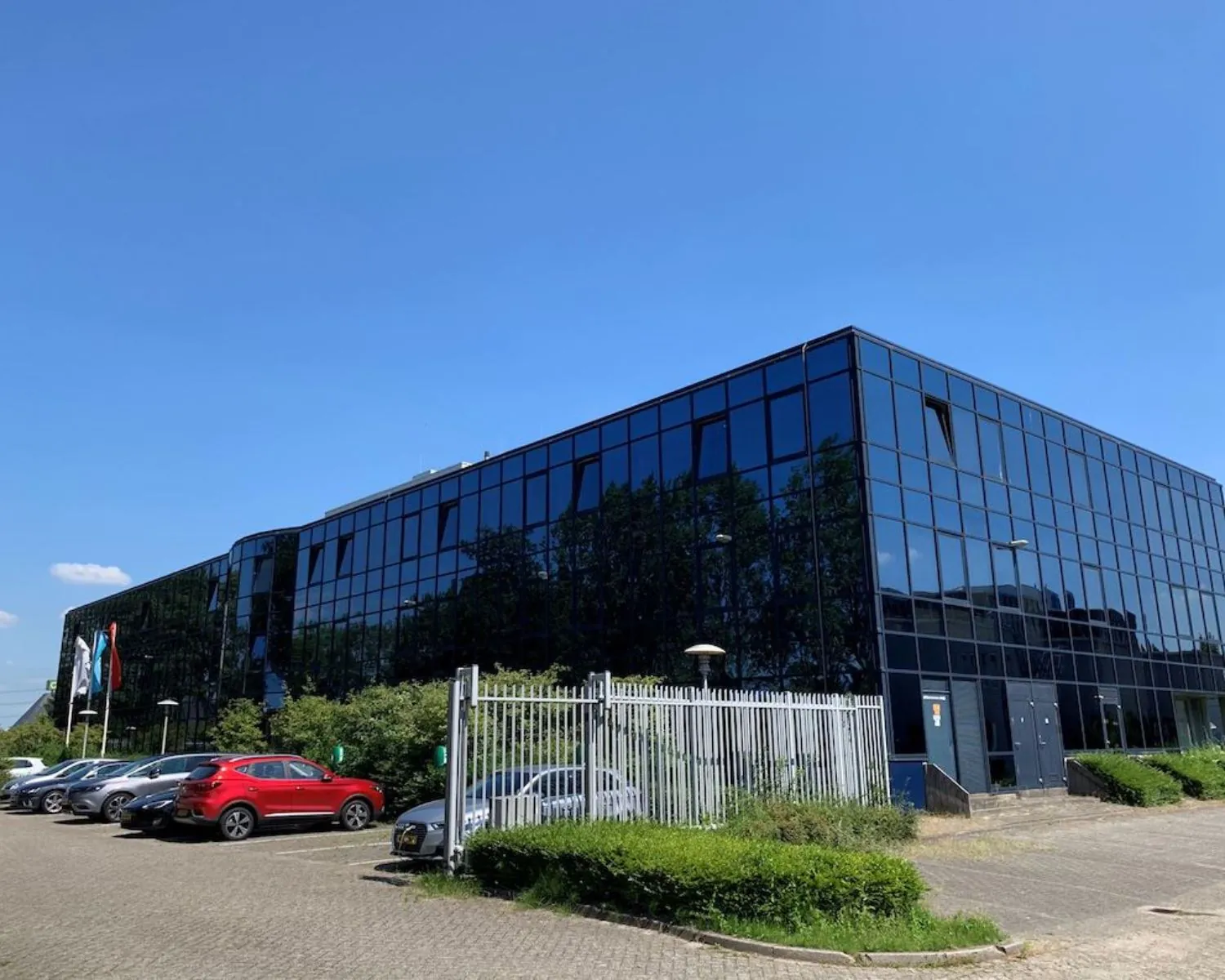 Modern kantoorgebouw met spiegelende ramen aan de Elisabethhof in Leiderdorp, met parkeerplaatsen ervoor.