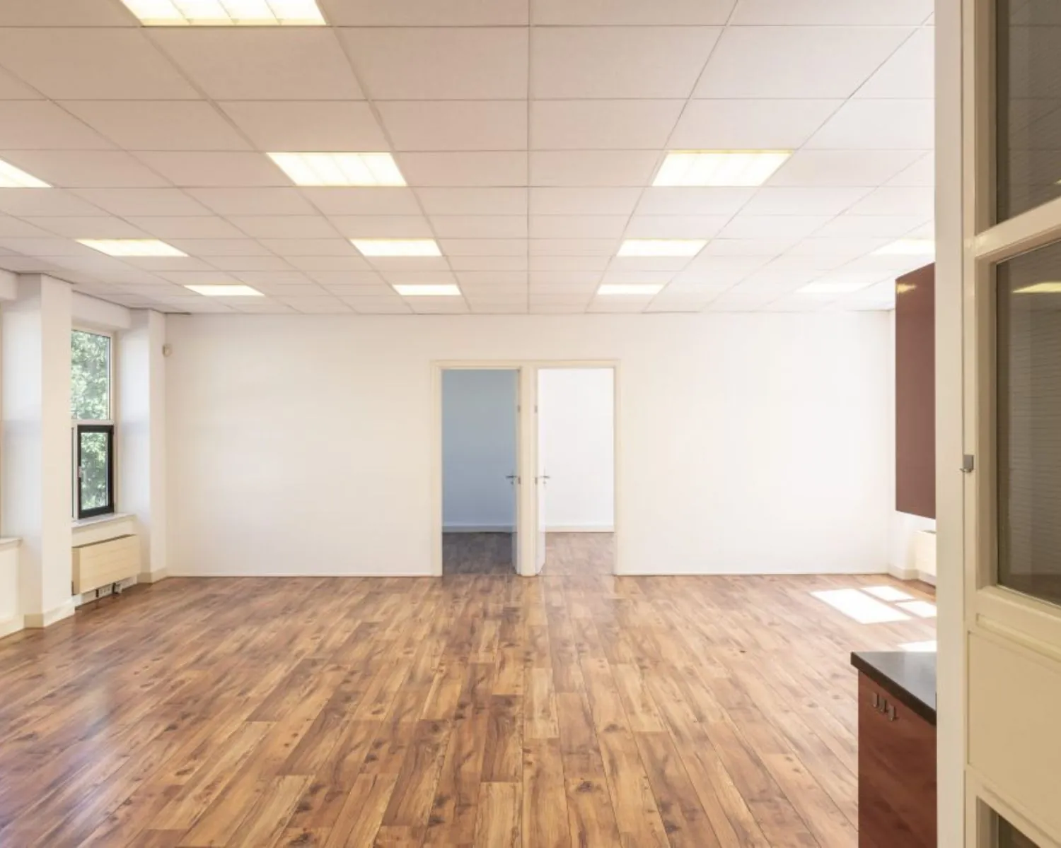 Licht en ruim kantoor met houten vloer aan de Wilhelminastraat 43a in Haarlem.